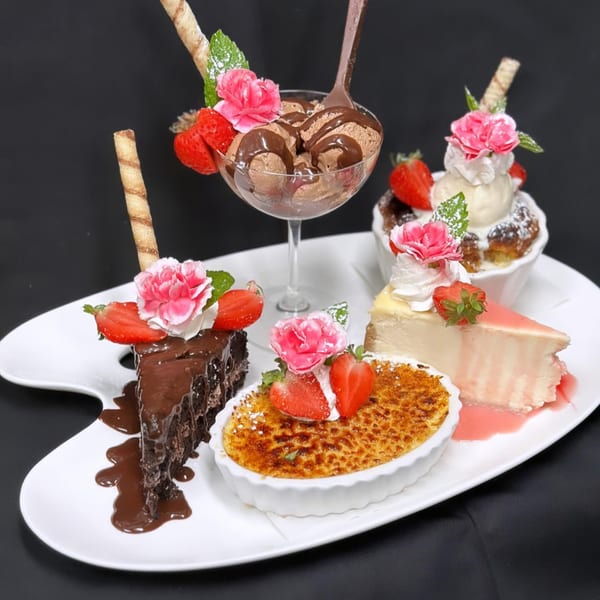 A dessert platter with chocolate cake, crème brûlée, cheesecake, bread pudding, and chocolate ice cream.