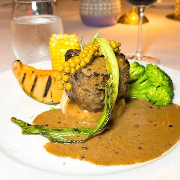 La Brochette Bistro's steak with green peppercorn sauce, grilled squash, corn, and broccoli.